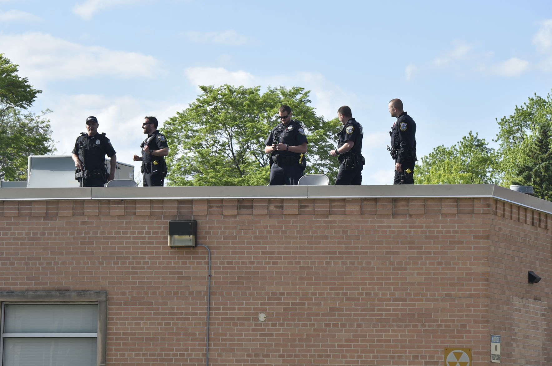 Five Milwaukee Police officers stand on the roof of District 5 precinct on Milwaukee's north side